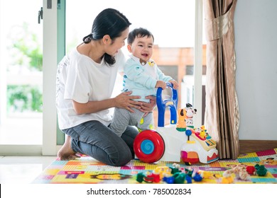 Asian Mother And Baby Training Walking With Walker Toy. This Immage Can Use For Baby, Family, Education, And Play Concept.