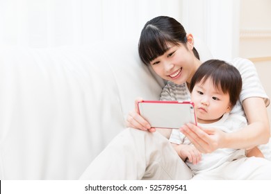 Asian Mother And Baby Using Smart Phone 