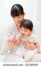 Asian Mother And Baby Using Smart Phone 