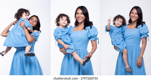 Asian Mother And Caucasian Daughter Stand And Wear Same Blue Blouse Dress Together. Little Girl Hold Mom Hand And Smile With Love. White Background Isolated