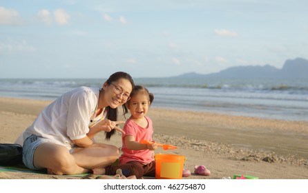 Asian Mother And Child Playing Sand On Tropical Beach.