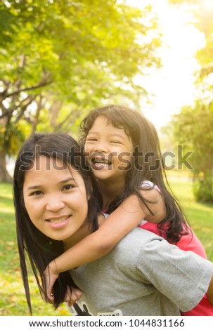 Asian Mother and Child playing together in the garden on holiday summer concept