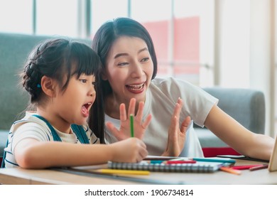 Asian Mother And Child Saying Hi To The Teacher In Online School Education At Home. For New Normal Online Education Concept.