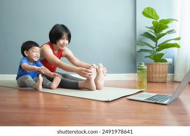 Asian Mother and child stretching together on yoga mat at home. Indoor fitness activity. Healthy lifestyle and family exercise concept. - Powered by Shutterstock