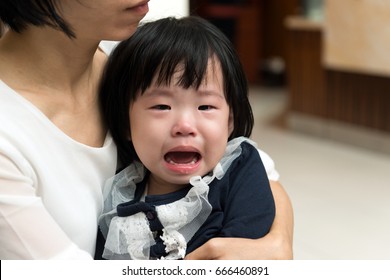 Asian Mother Cuddling Her Little Crying Child