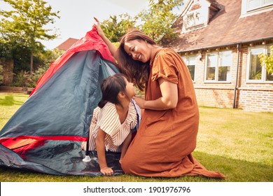 Asian Mother With Daughter In Garden At Home Putting Up Tent For Camping Trip Together - Powered by Shutterstock