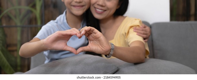 Asian Mother And Daughter Making Heart With Their Hands And Smiling To Camera. Life Insurance, Love And Support In Family Relationships Concept
