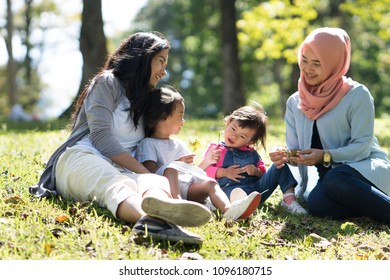 Asian Mother And Daughter Playdate With Friends In The Park Together