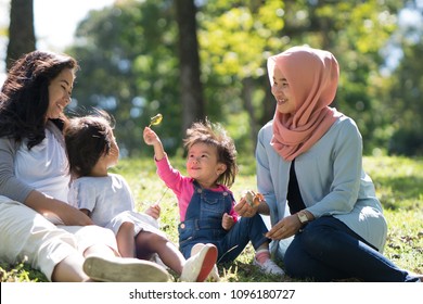 Asian Mother And Daughter Playdate With Friends In The Park Together