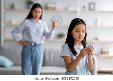 Asian Mother And Daughter Quarreling Because Of Overuse The Smartphone, Girl Not Paying Attention To Her Mom. Social Problem Between Parents And Children