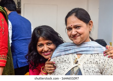 Asian Mother Daughter Smiling And Posing For Photo. They Are Wearing Winter Clothes   And Traditional Make Up Like Bindi And Lipstic. 