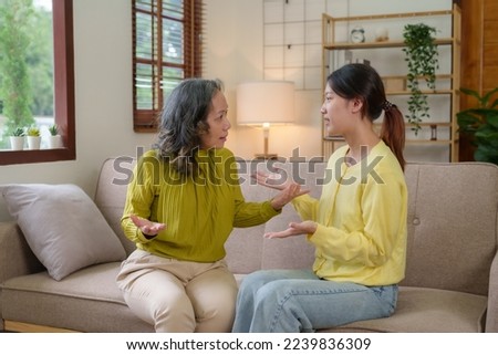 Asian mother and daughter spend their vacation in the living room not talking to each other and angry with each other Both of them showed emotion to each other.