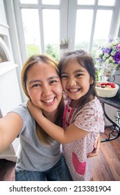 Asian Mother And Daughter Taking Selfie Photograph Together