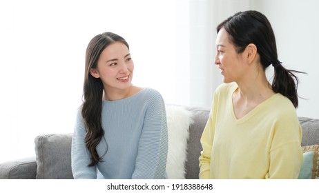 asian mother and daughter talking in the living room