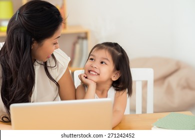 Asian Mother And Daughter Using Laptop At Home