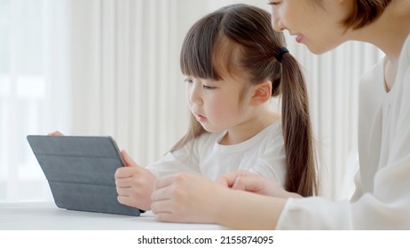 asian mother and daughter using tablet computer - Powered by Shutterstock