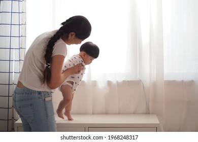 Asian Mother Encouraging Her Cute Baby To Walk At Home Baby Learning Exercises Of Walking The First Steps Mother Teaching Child Movement And Activity And Family Lifestyle Baby Growth And Development