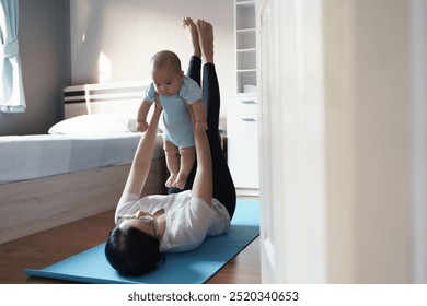 Asian Mother exercising with baby on yoga mat in bedroom. Indoor shot of bonding and fitness activity. Parenting and wellness concept - Powered by Shutterstock