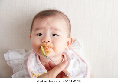 Asian Mother Feeding Daughter Baby Food