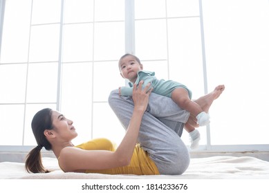 Asian Mother Fit And Play Yoga For Lose Weight After Delivery A New Born Baby In Home, Sports Mother Is Engaged In Fitness Mom, Mother, Exercise And Healthy Concept.