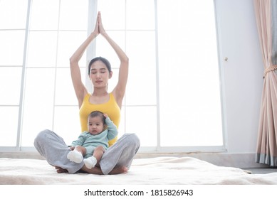 Asian Mother Fit And Play Yoga For Lose Weight After Delivery A New Born Baby In Home, Sports Mother Is Engaged In Fitness Mom, Mother, Exercise And Healthy Concept.