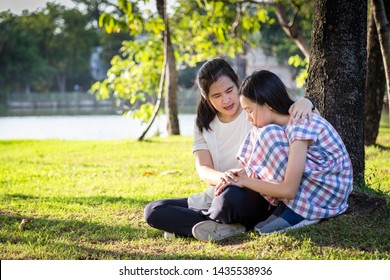 Asian mother give advice,talking to her daughter to encourage her ,sad child girl crying,discourage and mom comforting in summer outdoor park,care,love,family life and consultation concept