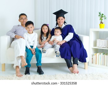 Asian Mother In Graduation Gown.Taking Photo With Family.