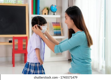 Asian mother help her daughter wearing medical mask for protection Covid-19 or coronavirus outbreak in home to prepare go to school when back to school order. - Powered by Shutterstock