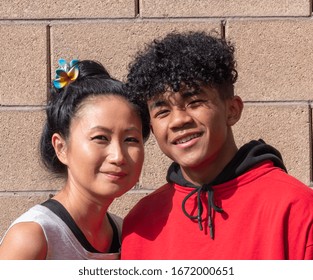 Asian Mother With Her African American Mixed Race Teenage Son.  Mixed Race Mother And Teenage Son Smiling.