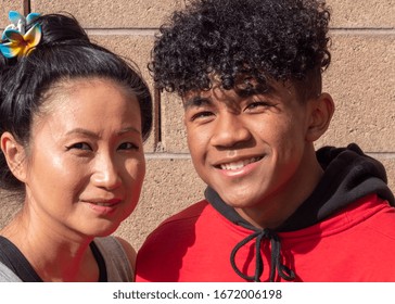 Asian Mother With Her African American Mixed Race Teenage Son.  Mixed Race Mother And Teenage Son Close Up Smiling.