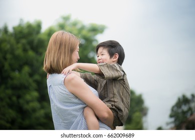 Asian Mother And Her Son Playing Together In The Park