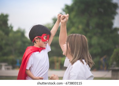 Asian Mother And Her Son Playing Together In The Park,Boy In Superhero's Costume.