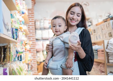 Asian Mother With Her Toddler Boy Shopping In The Baby Shop