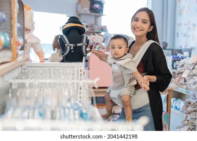 Asian Mother With Her Toddler Boy Shopping In The Baby Shop