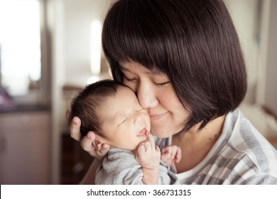 Asian Mother Holds Her  Newborn Baby