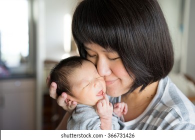 Asian Mother Holds Her  Newborn Baby