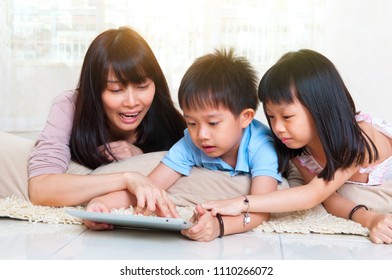 Asian mother and kids having fun with tablet computer - Powered by Shutterstock