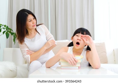 Asian Mother Looking At Her Sleepy Daughter