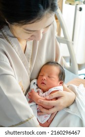 Asian Mother With Newborn Baby In The Hospital. New Born Baby Boy Resting In Mothers Arms. A Beautiful Moment Little Cute Newborn Baby In Her Mother's Arm In A Hospital.