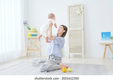 Asian Mother Playing With Her Baby