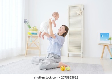 Asian Mother Playing With Her Baby At Home