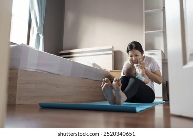 Asian Mother playing with her baby on a yoga mat in a bedroom, both enjoying the moment. - Powered by Shutterstock