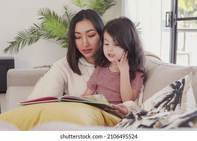 Asian Mother Read Book To Her Mixed Daughter Girl At Home, Spending Family Quality Time Together, Homeschooling Education Concept