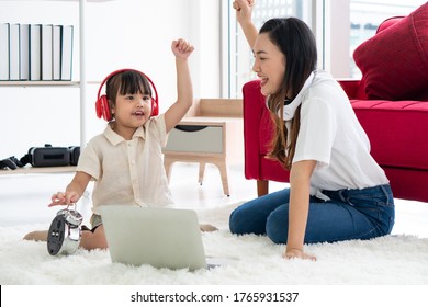 Asian Mother With Smiling Face Teaching Her Young Daughter To Study From Computer Or Laptop Program At Home. Homeschooling And Family Together Concept