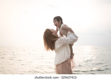 Asian Mother And Son Playing On The Beach,vintage Filter