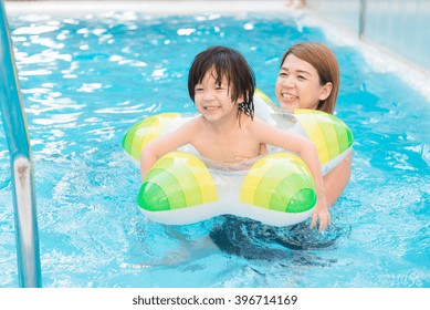 Asian Mother And Son Playing In Swimming Pool