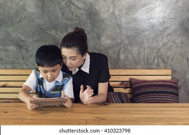 Asian Mother And Son Playing Tablet Together