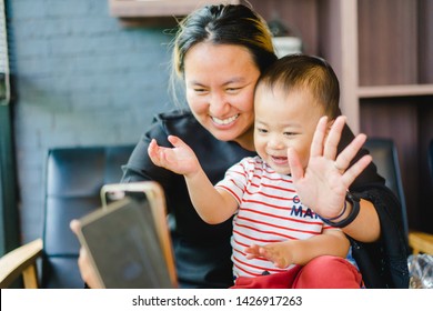 Asian Mother and son using smartphone video call camera in restaurant.Mother and baby boy child talking to each other through a video call on a smartphone. - Powered by Shutterstock