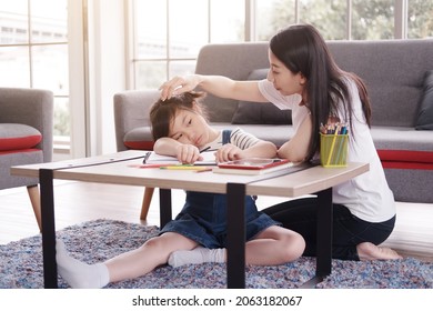 Asian Mother Take Care A Little Girl Child Is Drawing And Painting With Wooden Colored Pencils On Paper Together In Living Room. She Is Online Learning And Bored About Homeschool And Educational.