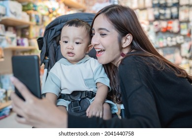 Asian Mother Take Selfie With Her Son While Shopping In The Mall